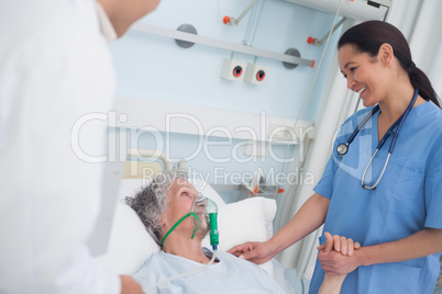 Nurse smiling to a patient while touching her hand