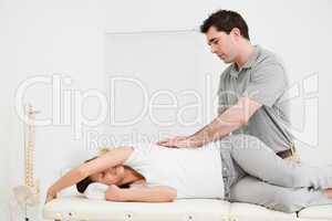 Brunette woman lying on the side while being massaged