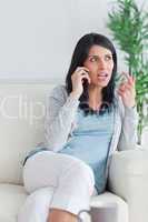 Woman talking on the phone while sitting on a sofa