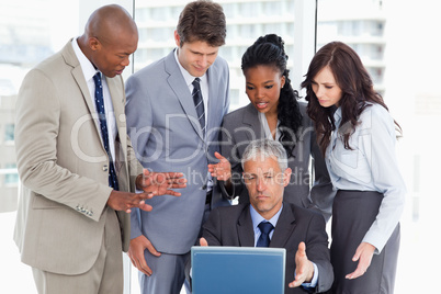 Business team seriously talking in front of a laptop