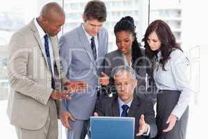 Business team seriously talking in front of a laptop