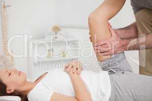 Physiotherapist holding the thigh of a patient