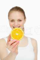 Woman presenting an orange slice while smiling