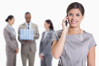 Close-up of a woman smiling on the phone and co-workers with a l