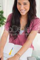Portrait of a smiling brunette student using a laptop