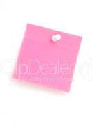 Close up of a pink adhesive note with pushpin