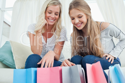 Girls looking into their shopping bags for a item to try on