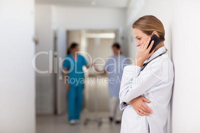 Woman doctor phoning on the hallway