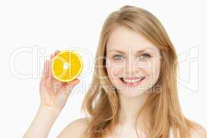 Joyful woman presenting an orange