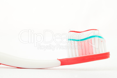 Toothpaste on a red toothbrush