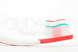 Toothpaste on a red toothbrush