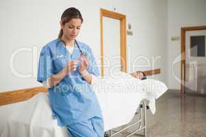 Nurse leaning on a medical bed