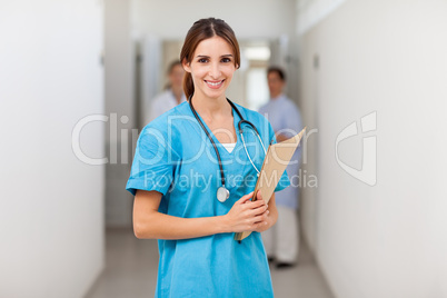 Nurse smiling while holding a file