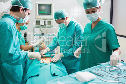 Nurse holding surgical tool next to operating table