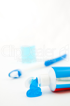 Blue toothbrush next to a tube of toothpaste