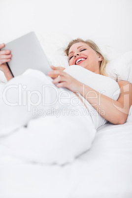 Blonde laughing while using an ebook reader