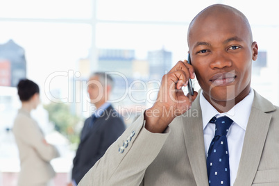 Serious businessman in a suit talking on the phone while his tea