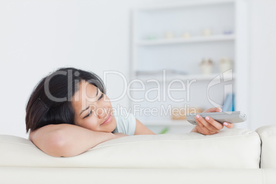 Smiling woman resting her head on her arm as she sits on a sofa