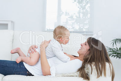Mother lying on a sofa holding a baby on her chest