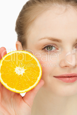 Close up of a blonde-haired girl presenting an orange