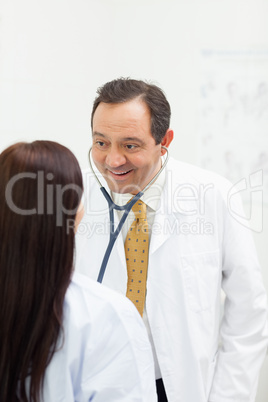 Smiling woman auscultating a woman while smiling