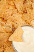 Bowl of dip surrounded by nachos