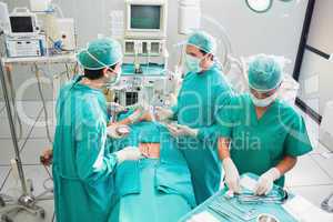 Team of surgeons operating an uncounscious patient