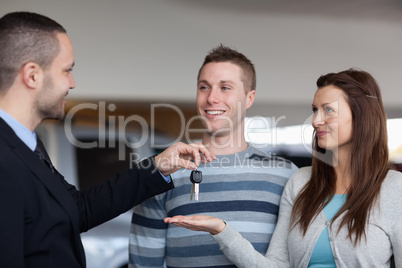 Businessman giving car keys to a woman