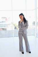 Businesswoman standing upright with her hand on her chin and wit