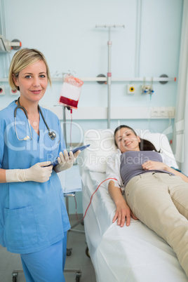 Nurse standing next to a female patient