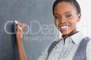 Black teacher holding a chalk while smiling