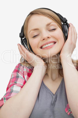 Smiling woman with closed eyes listening music