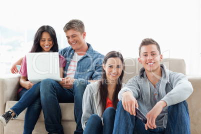 A man and woman sitting on the ground while another man and woma