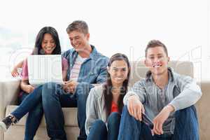 A man and woman sitting on the ground while another man and woma