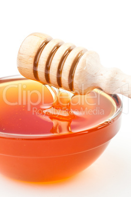 Honey sticky trickle dropping in a honey bowl