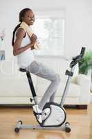 Black woman on an exercise bike smiling