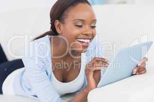 Black woman smiling while touching a tablet computer