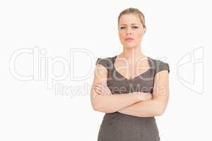 Uneasy woman standing with her arms crossed