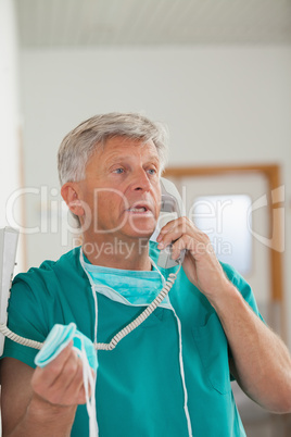 Surgeon talking while holding a phone