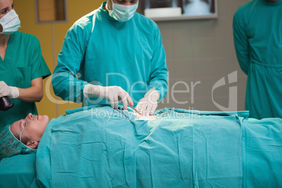 Surgeon opening the belly of a patient