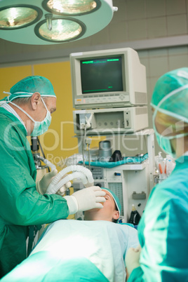 Surgeon putting an oxygen mask on a patient