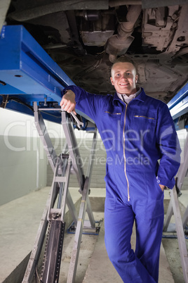 Mechanic leaning on a machine while holding a spanner