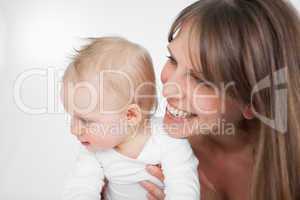 Laughing woman holding her cute daughter