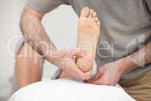 Doctor placing the foot of a patient on a pillow