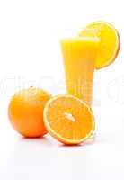 One orange and a half near a glass of orange juice