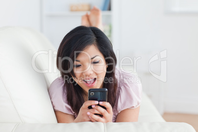 Woman resting on a couch and holding a phone