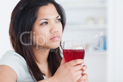 Thinking woman holding a glass of red wine