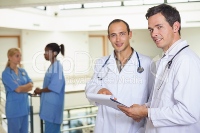 Doctors looking at camera next to nurses