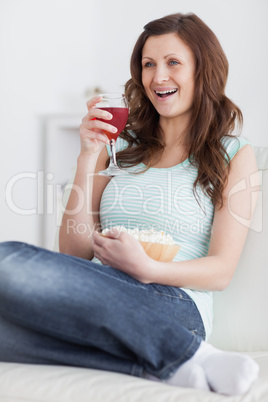 Woman holding a glass of wine and a bowl of popcorn