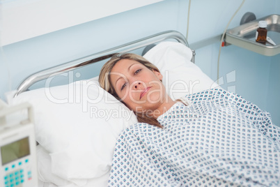 Woman lying on a bed while looking at camera